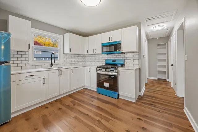 a kitchen with stainless steel appliances a stove top oven a sink and a refrigerator
