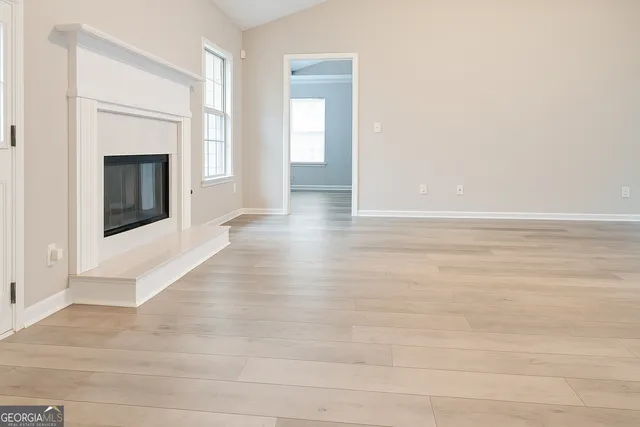 a view of a livingroom with wooden floor and a fireplace