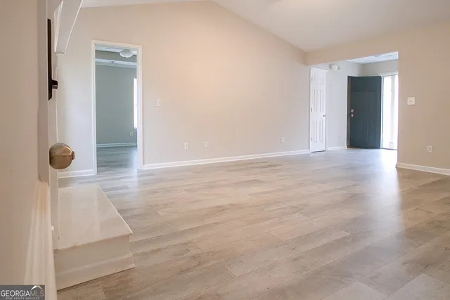 an empty room with wooden floor and mirror