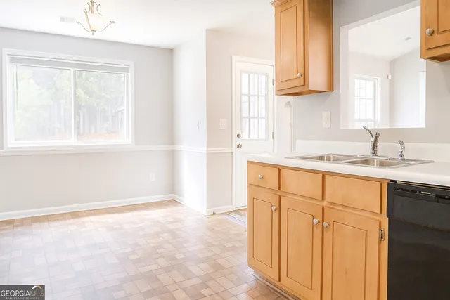 a kitchen with granite countertop cabinets sink and a window