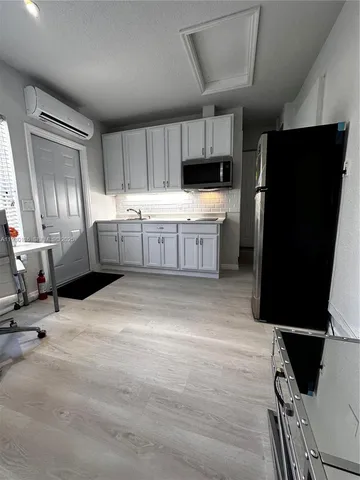 a kitchen with a sink a refrigerator and cabinets