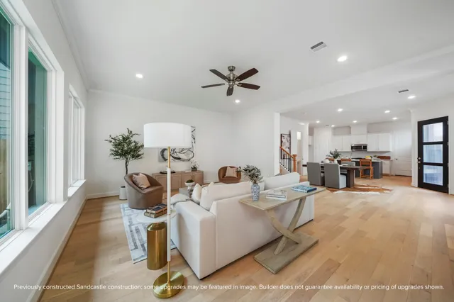 a living room with furniture a table and kitchen view