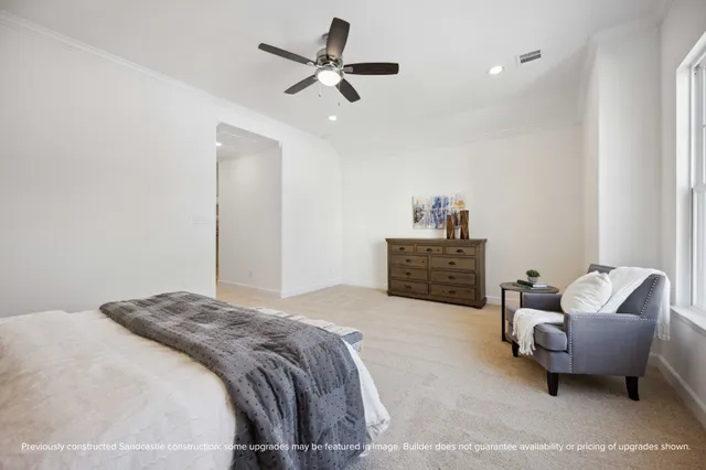 a spacious bedroom with a bed a couch and a chandelier