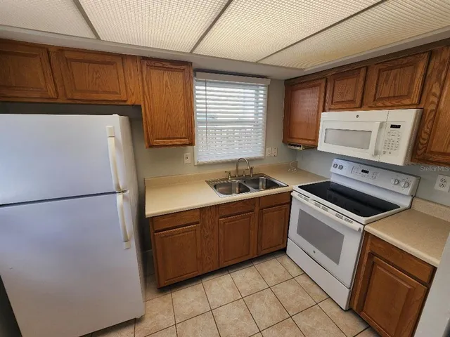 a kitchen with a refrigerator sink and cabinets
