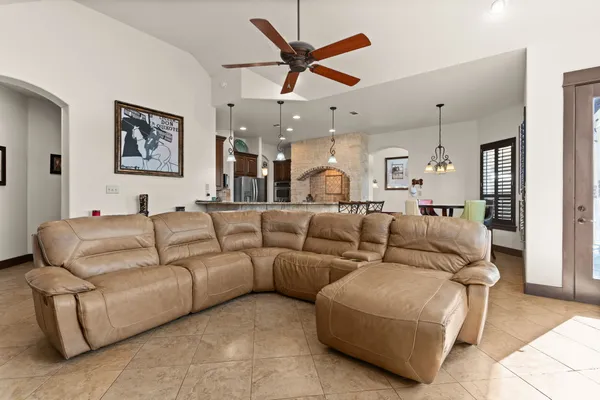 a living room with furniture kitchen view and a chandelier