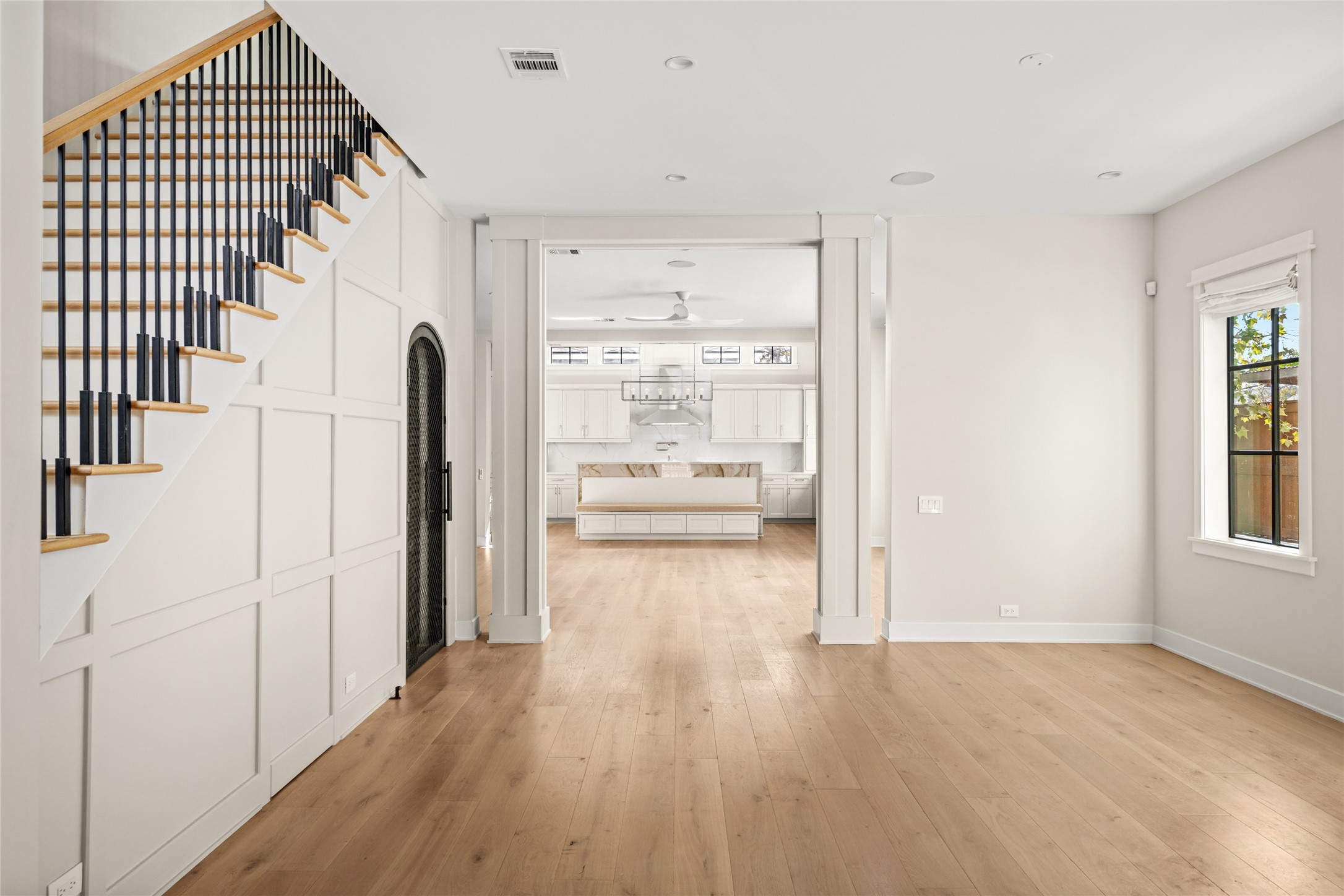1136 Woodland Street Houston, TX 77009 - Photo 13 of 50 Symmetrical columns frame a sightline straight through to the kitchen, highlighting the home’s open flow and architectural cohesion.