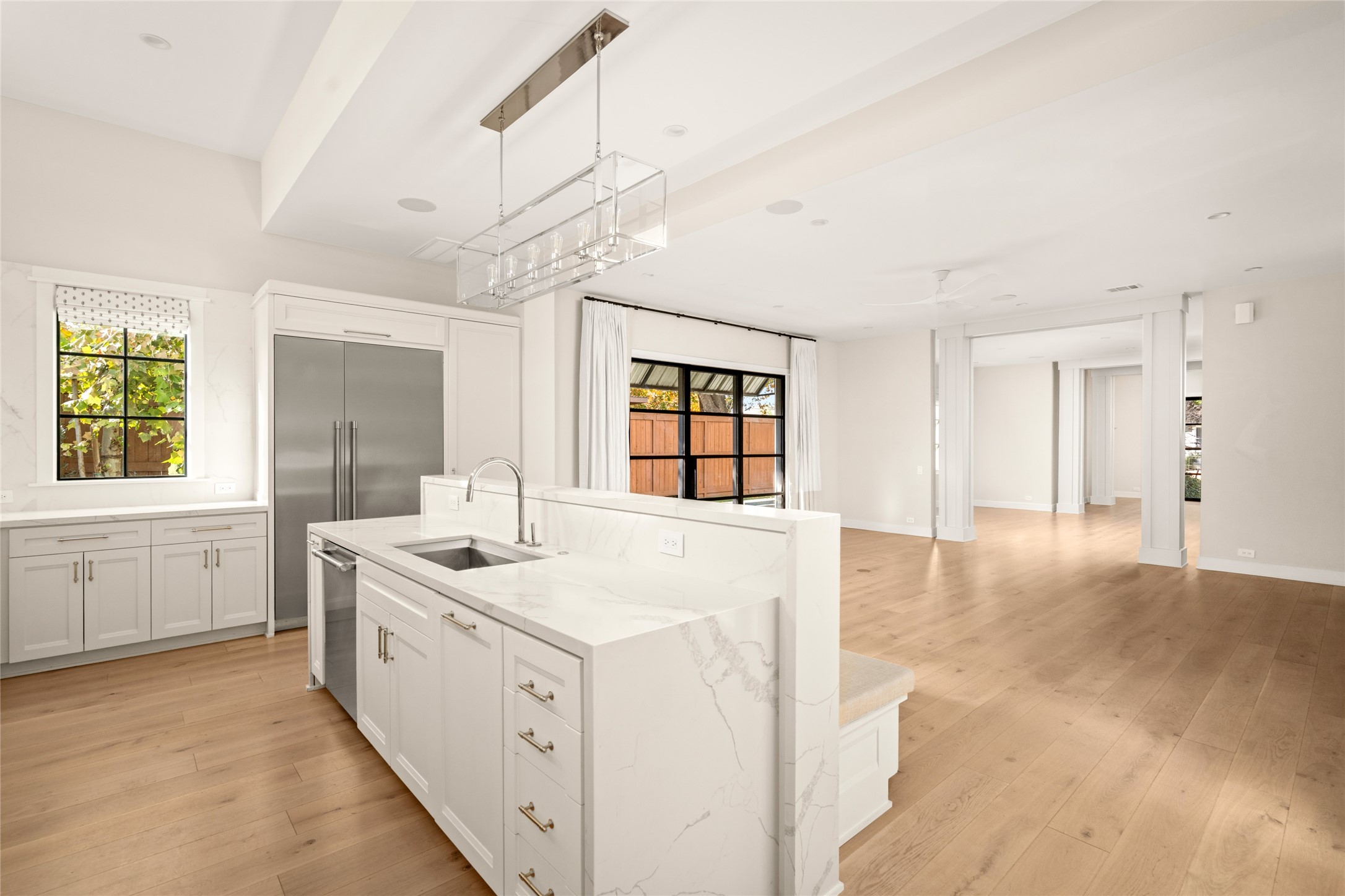 1136 Woodland Street Houston, TX 77009 - Photo 22 of 50 Oversized marble island with integrated sink and seating anchors the kitchen while opening seamlessly to the main living spaces beyond.