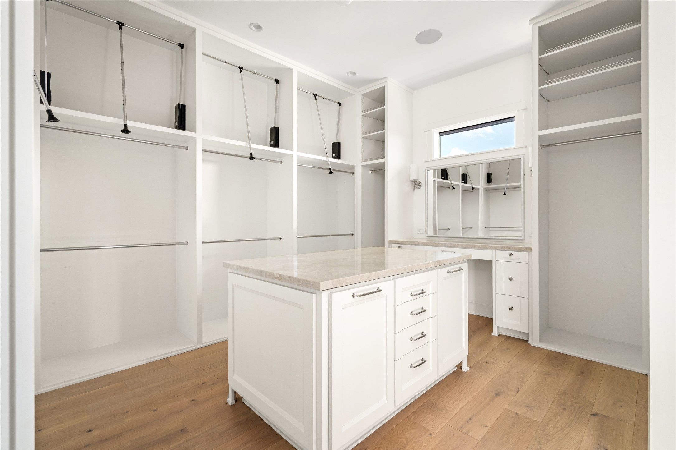 1136 Woodland Street Houston, TX 77009 - Photo 29 of 50 Custom-designed closet featuring a dressing vanity, center island dresser, and double-height hanging space—beautifully blending form and function.