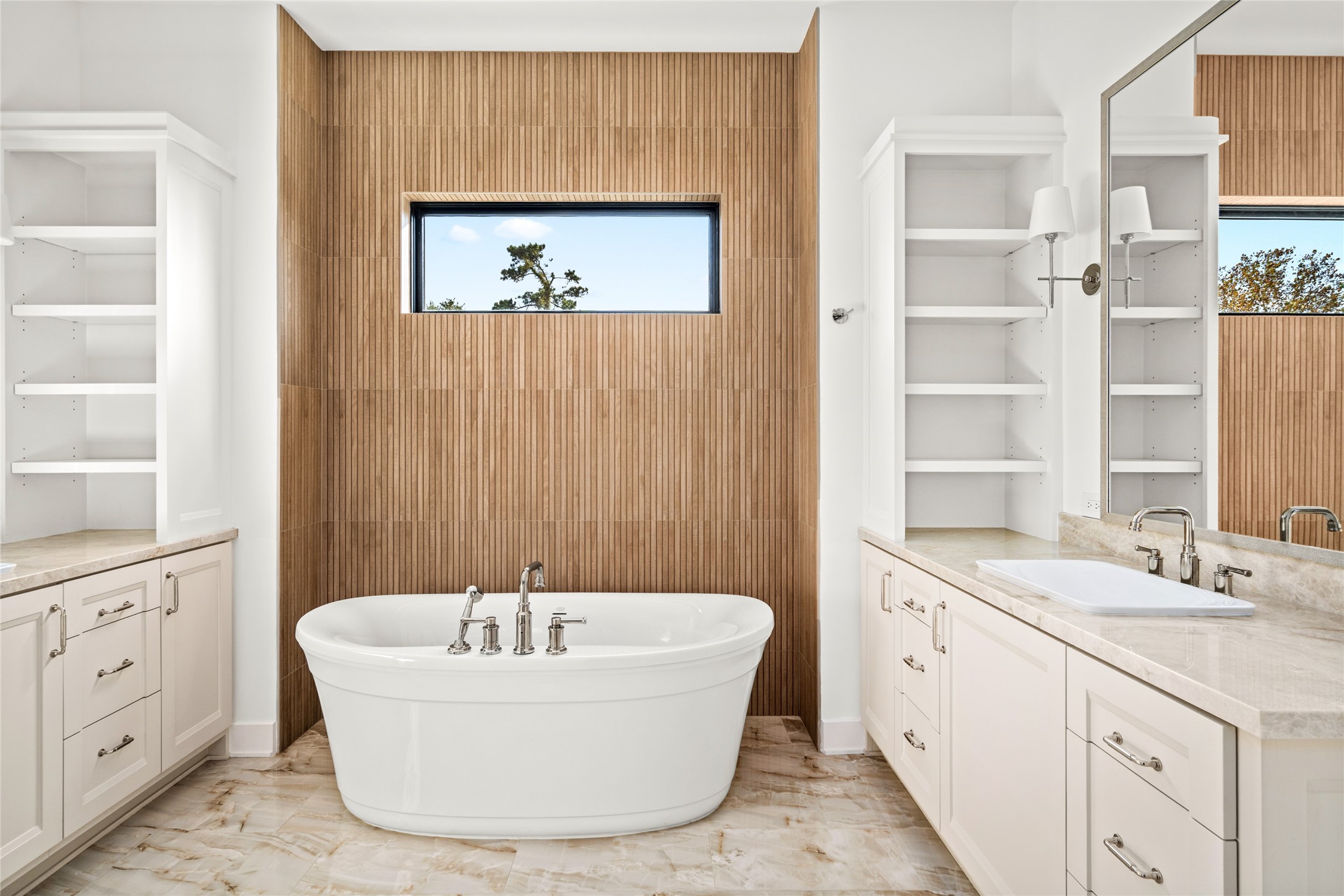 1136 Woodland Street Houston, TX 77009 - Photo 32 of 50 A dramatic focal wall clad in warm, textured tile frames the soaking tub beneath a horizontal window, balancing privacy with natural light.