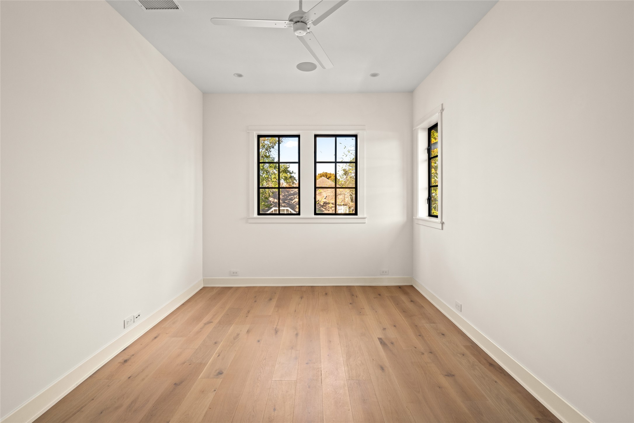 1136 Woodland Street Houston, TX 77009 - Photo 37 of 50 Bright secondary bedroom with wide-plank hardwood floors, crisp white walls, and large windows bringing in abundant natural light.