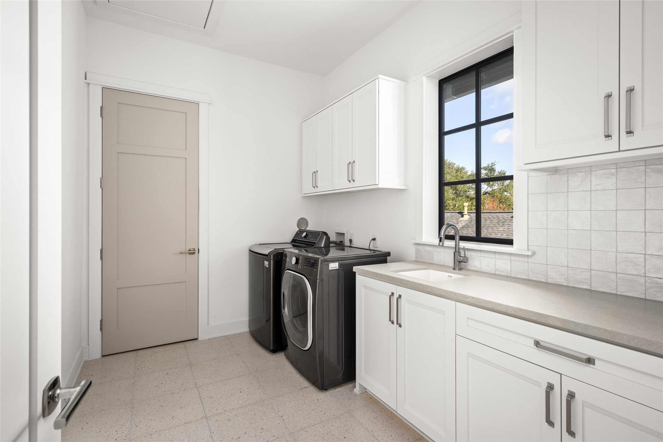 1136 Woodland Street Houston, TX 77009 - Photo 41 of 50 Well-appointed laundry room with cabinetry, sink, counter space, washer and dryer included, and a large window for natural light.