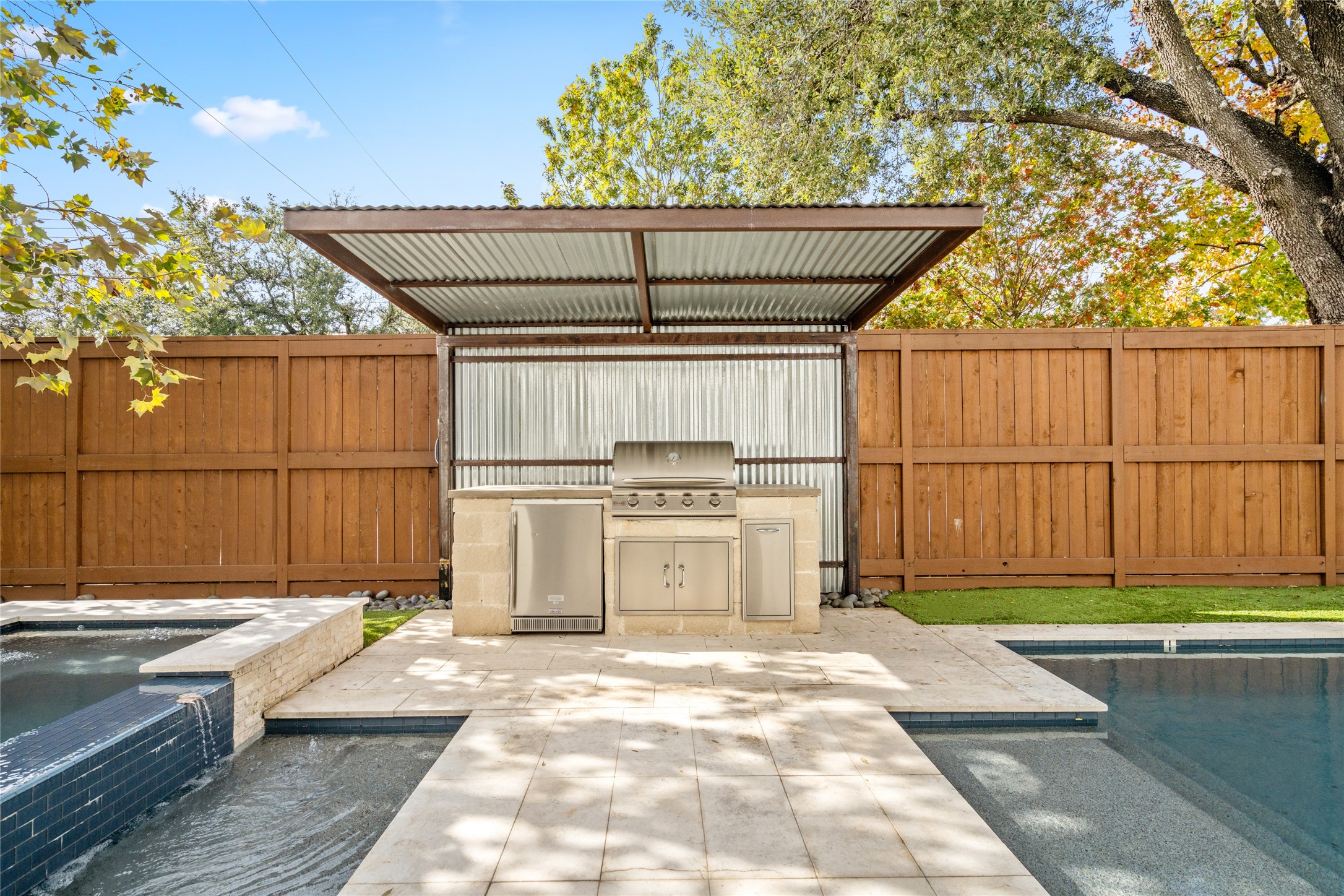 1136 Woodland Street Houston, TX 77009 - Photo 47 of 50 Resort-style backyard featuring a raised spa, stone-clad outdoor kitchen, and covered grilling area designed for entertaining.