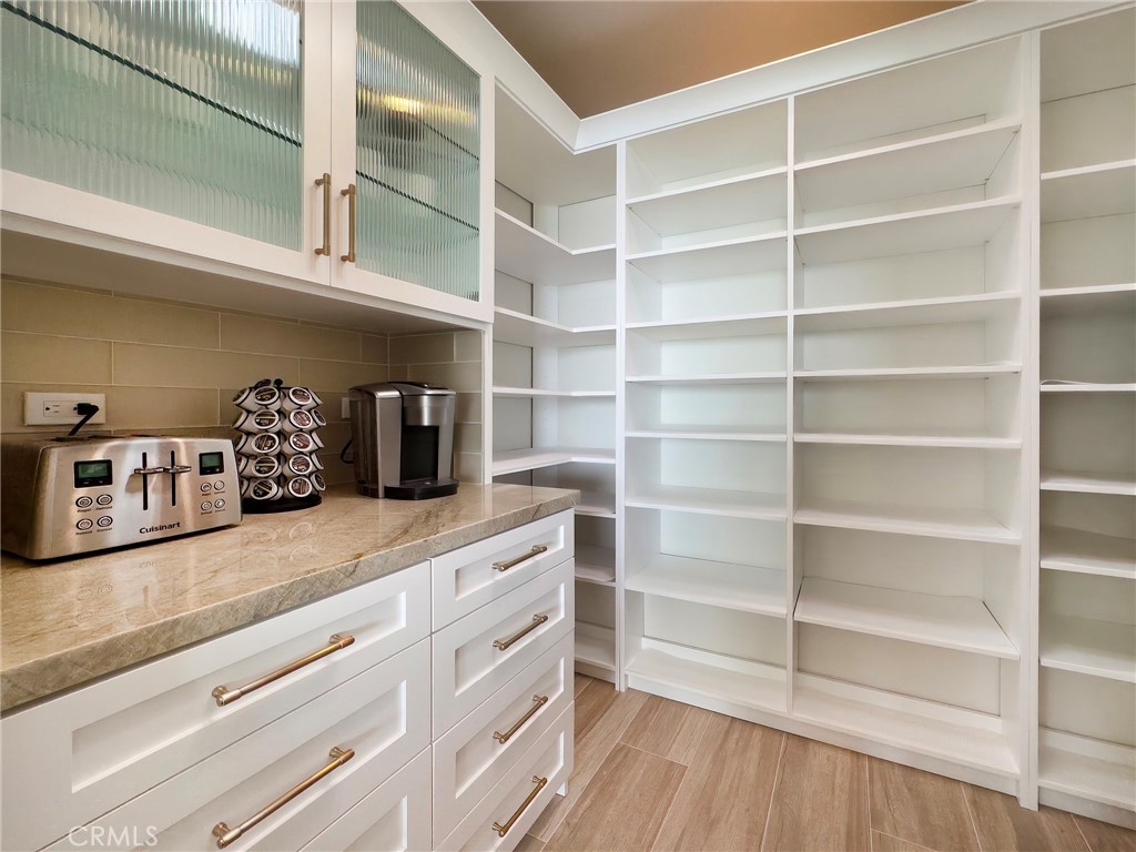 33971 Nauticus Isle Dana Point, CA 92629 - Photo 11 of 27 a kitchen with a wooden floor and cabinets