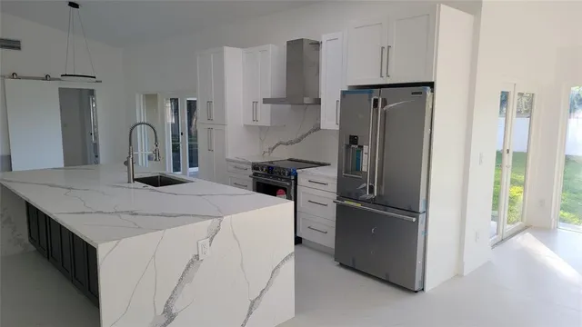 a kitchen with stainless steel appliances granite countertop a refrigerator and a sink