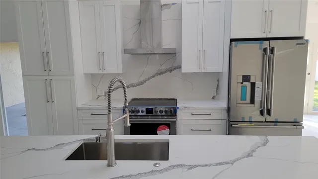 a kitchen with stainless steel appliances kitchen island granite countertop a refrigerator and a stove