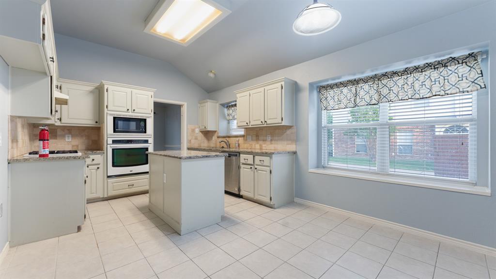 525 Mustang Ridge Drive Murphy, TX 75094 - Photo 4 of 26 a kitchen with stainless steel appliances granite countertop a refrigerator oven a sink dishwasher and white cabinets with wooden floor
