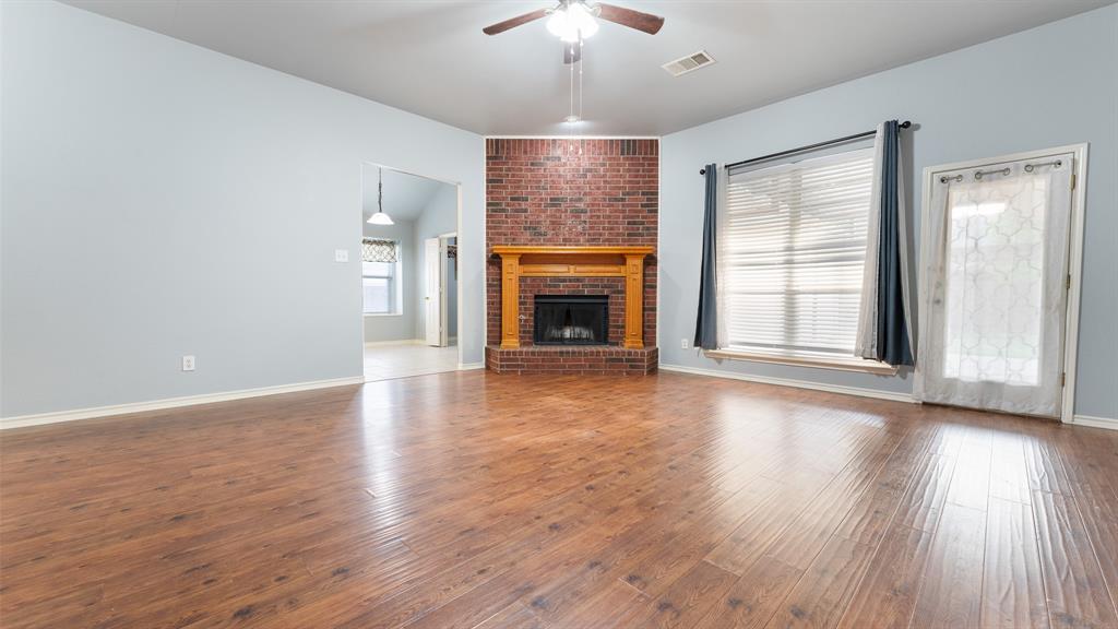 525 Mustang Ridge Drive Murphy, TX 75094 - Photo 8 of 26 an empty room with wooden floor fireplace and windows