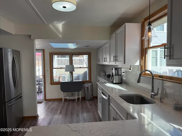 a kitchen with stainless steel appliances granite countertop a stove a sink and a refrigerator