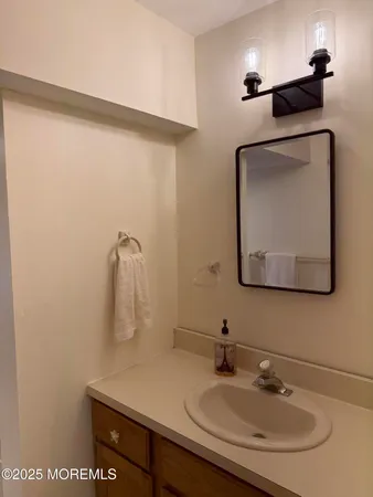 a bathroom with a sink vanity and a mirror