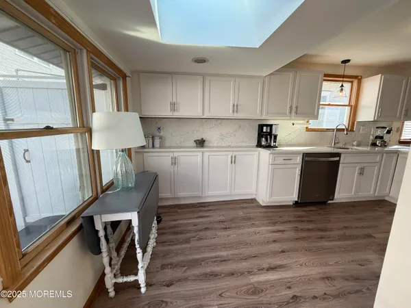 a kitchen with wooden floors and white cabinets