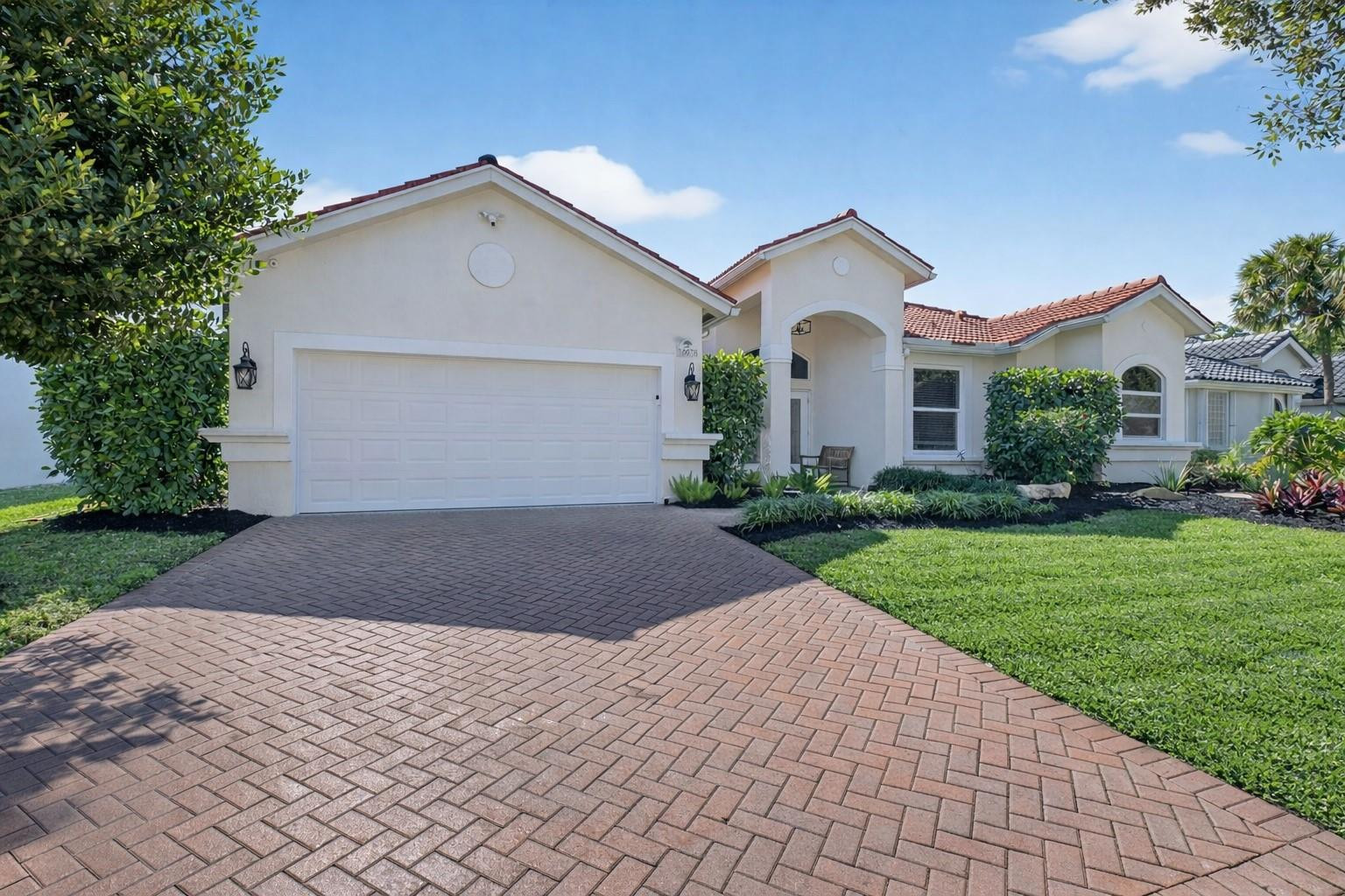 10078 Lexington Estates Boulevard Boca Raton, FL 33428 - Photo 2 of 49 a front view of a house with a yard and garage