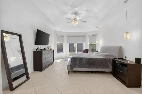 a bedroom with a bed a couch and a flat screen tv