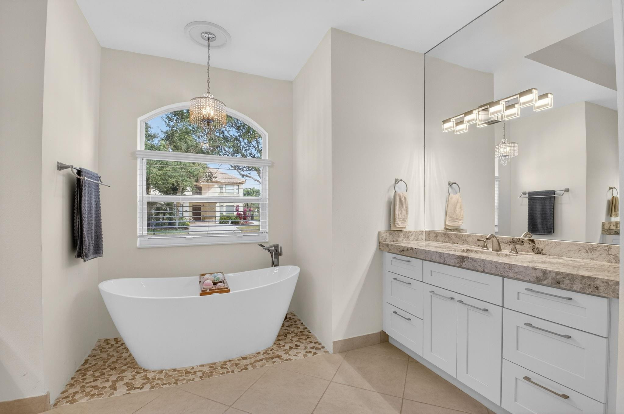 10078 Lexington Estates Boulevard Boca Raton, FL 33428 - Photo 33 of 49 a bathroom with a granite countertop sink a large mirror and a bathtub