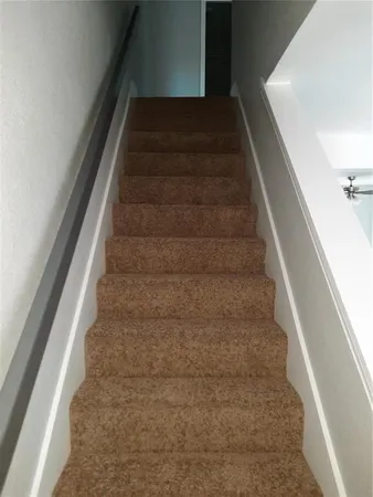 a view of staircase with white walls and windows