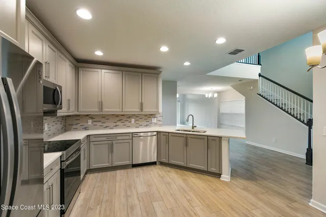 a kitchen with stainless steel appliances granite countertop a refrigerator stove a sink and a microwave