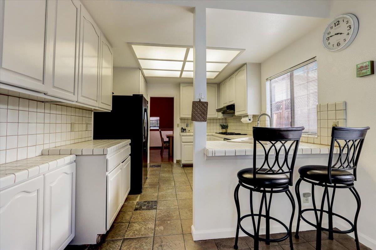 952 Corbel Common Fremont, CA 94539 - Photo 17 of 50 a kitchen with stainless steel appliances kitchen island granite countertop a table chairs in it and a window