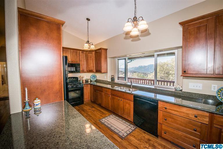 45220 Hammond Drive Three Rivers, CA 93271 - Photo 8 of 31 a kitchen with stainless steel appliances granite countertop wooden cabinets a stove a sink and dishwasher next to a window