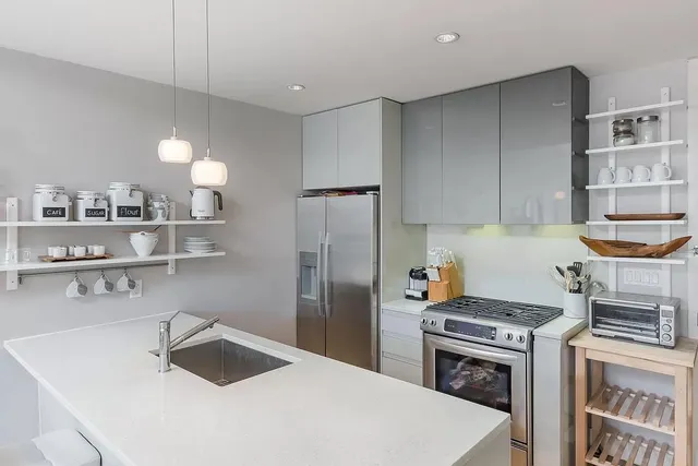 a kitchen with kitchen island a sink a stove and refrigerator