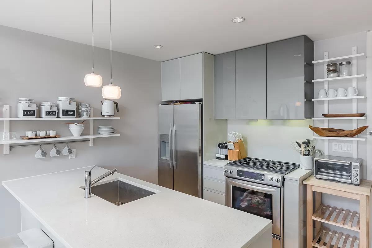 2-26 50th Avenue, Unit 11B Queens, NY 11101 - Photo 3 of 12 a kitchen with kitchen island a sink a stove and refrigerator