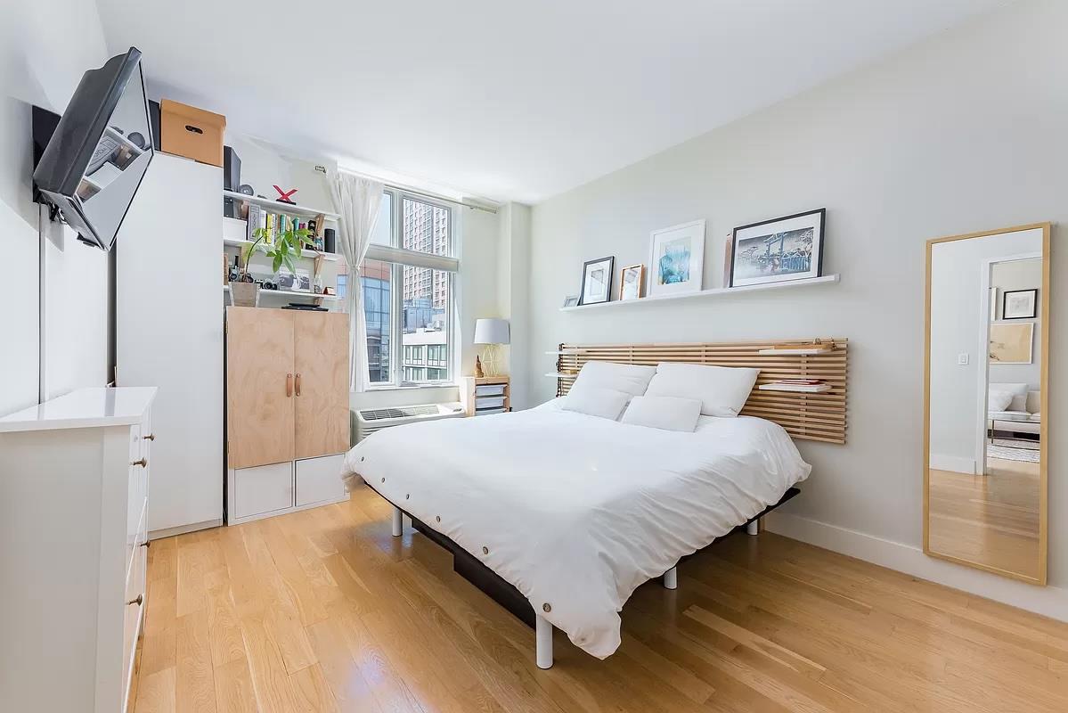 2-26 50th Avenue, Unit 11B Queens, NY 11101 - Photo 4 of 12 a bedroom with a bed closet and window