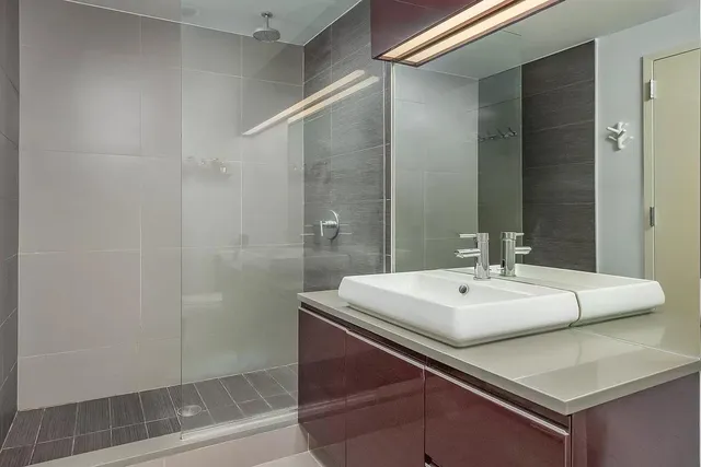 a bathroom with a sink a mirror and a shower