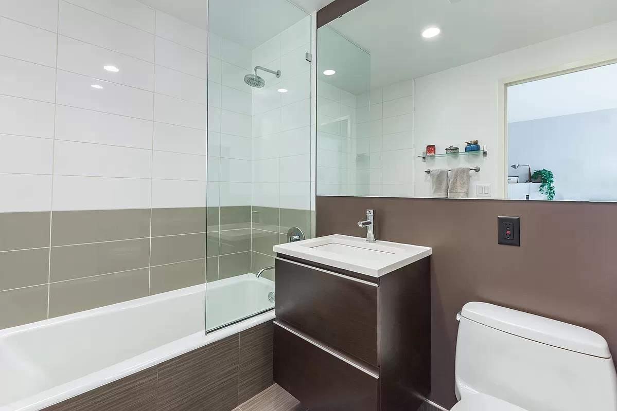 2-26 50th Avenue, Unit 11B Queens, NY 11101 - Photo 7 of 12 a bathroom with a sink a toilet and shower