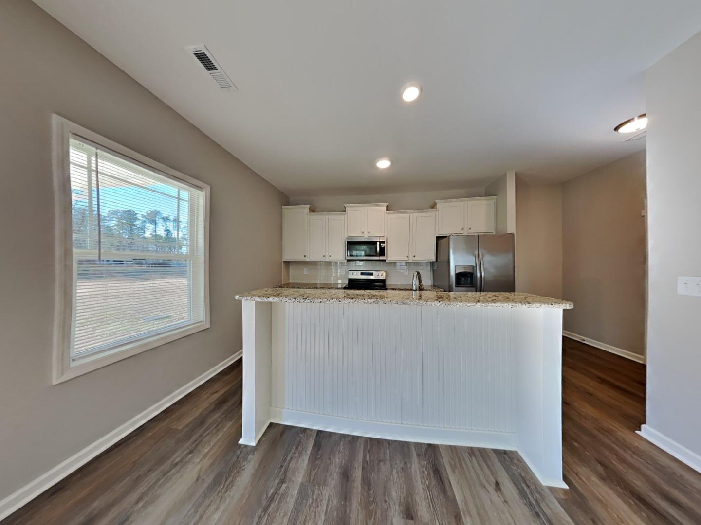 43 Wild Sage Circle Angier, NC 27501 - Photo 5 of 19 a living room with stainless steel appliances granite countertop a refrigerator a sink a stove and white cabinets with wooden floor