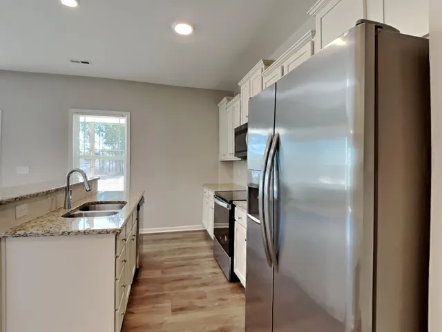 a kitchen with stainless steel appliances granite countertop a refrigerator a sink and dishwasher