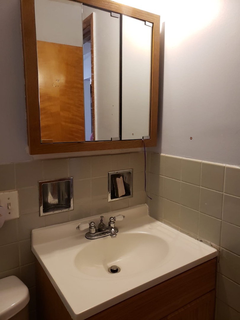 2000 West Arthur Avenue, Unit 2NW Chicago, IL 60645 - Photo 23 of 26 a bathroom with a sink and a mirror