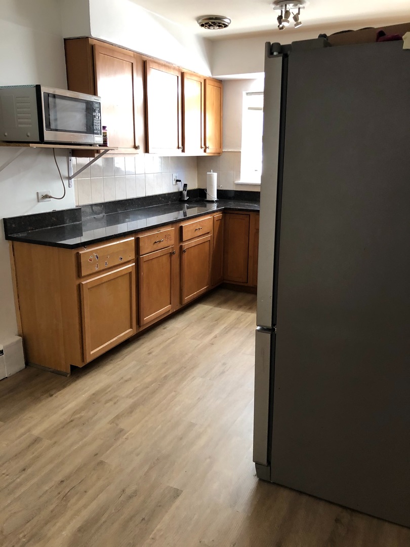 2000 West Arthur Avenue, Unit 2NW Chicago, IL 60645 - Photo 8 of 26 a kitchen with stainless steel appliances granite countertop a sink a stove a refrigerator a counter space and cabinets