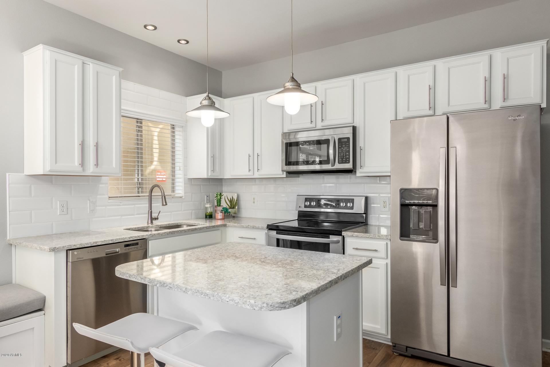 280 South Evergreen Road, Unit 1245 Tempe, AZ 85288 - Photo 9 of 28 a kitchen with stainless steel appliances granite countertop a white stove top oven a refrigerator a sink and dishwasher