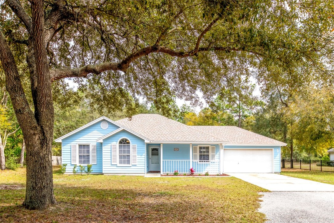 96438 Chester Road Yulee, FL 32097 - Photo 1 of 25 a front view of a house with a garden and yard