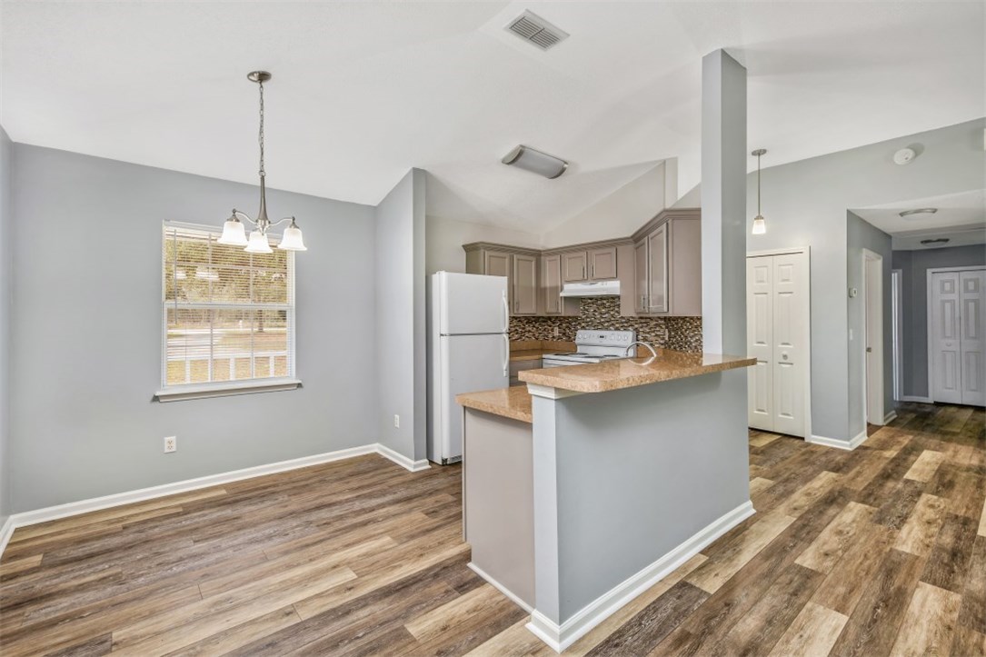 96438 Chester Road Yulee, FL 32097 - Photo 4 of 25 a kitchen with kitchen island white cabinets and stainless steel appliances