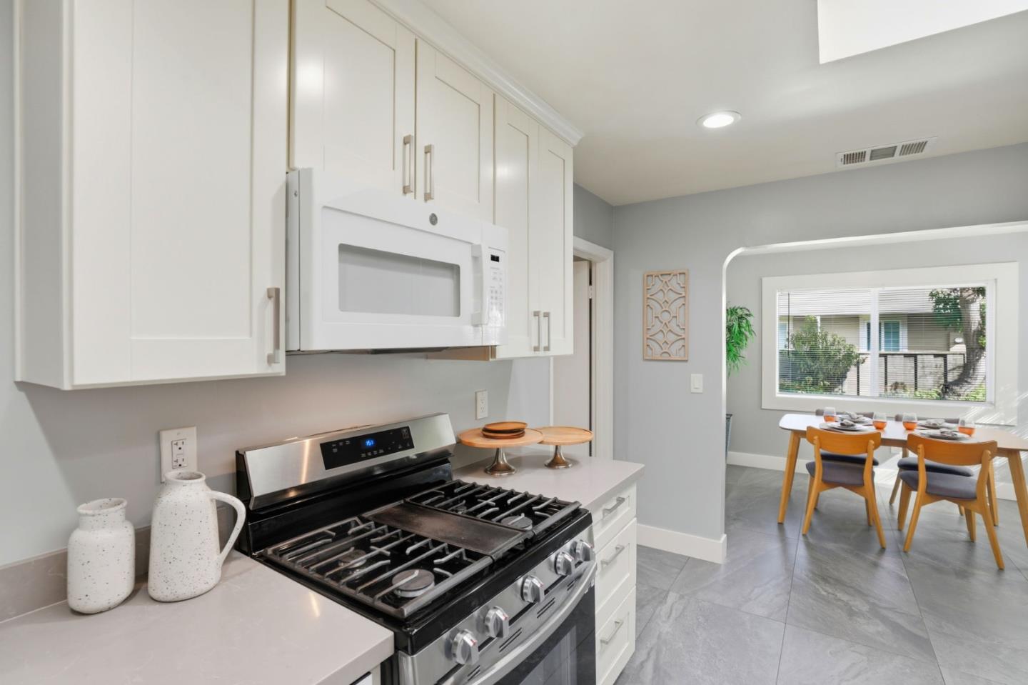 790 Shore Road Hollister, CA 95023 - Photo 15 of 70 a kitchen with stainless steel appliances granite countertop a stove top oven a sink a dining table and chairs with white cabinets