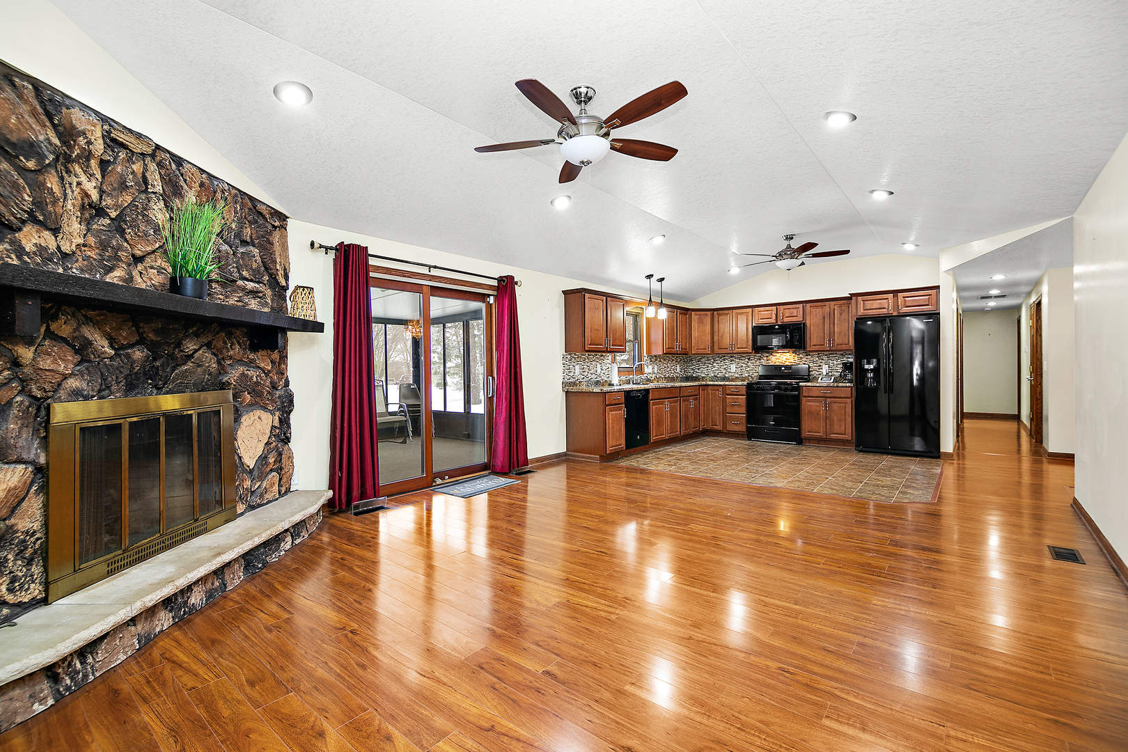 1173 Cecil Drive Kankakee, IL 60901 - Photo 5 of 32 a view of a livingroom with a flat screen tv wooden floor and a ceiling fan