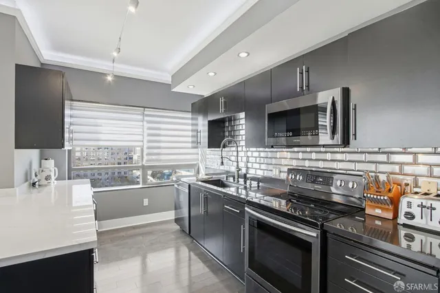 a kitchen with stainless steel appliances a sink stove and microwave