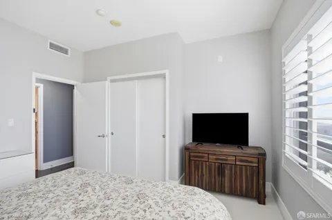 a bedroom with a flat screen tv and a bathroom