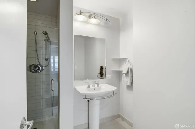 a bathroom with a sink a mirror and shower