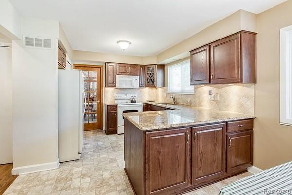 35882 Smithfield Road Farmington, MI 48335 - Photo 6 of 43 Renovated kitchen with granite countertops and travertine backsplash