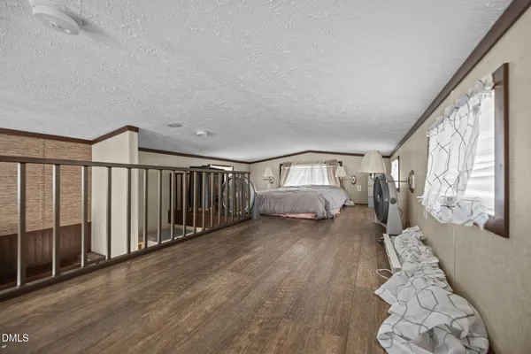 a bedroom with a bed and a flat tv screen on the dresser